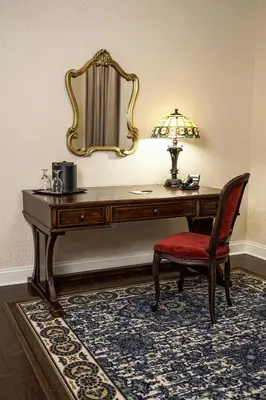 a dressing table with a chair and a mirror at The Mount Vernon Grand Hotel in Mount Vernon
