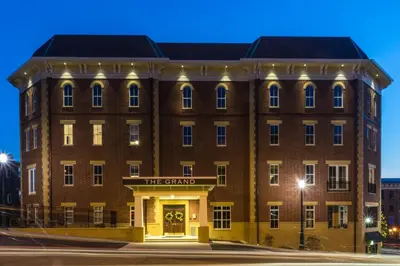 a large brick building with a sign that reads the stand at The Mount Vernon Grand Hotel in Mount Vernon