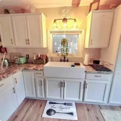a kitchen with white cabinets and a white sink at The Hideaway in North Canton