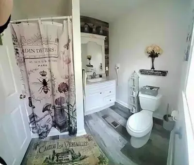 a bathroom with a toilet and a shower curtain at The Hideaway in North Canton