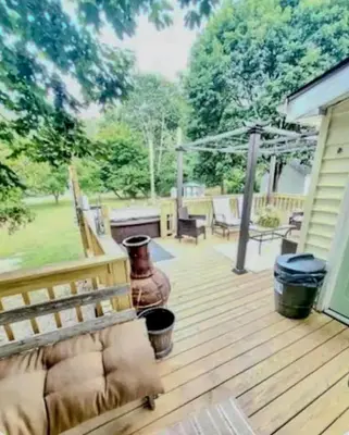 a wooden deck with a bench and a grill at The Hideaway in North Canton