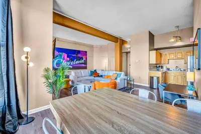 a living room with a dining table and a kitchen at Fun 2Bed Apt Skeeball Foosball FREE Parking in Cleveland
