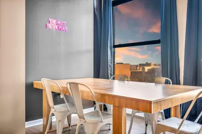 a wooden table and chairs in a room with a window at Fun 2Bed Apt Skeeball Foosball FREE Parking in Cleveland