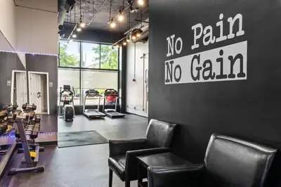 a gym with chairs and a sign that says no pain no gain at Funky 2B Apt in Downtown Cleveland FREE Parking in Cleveland