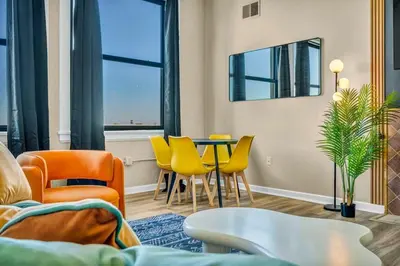 a living room with a table and yellow chairs at Funky 2B Apt in Downtown Cleveland FREE Parking in Cleveland