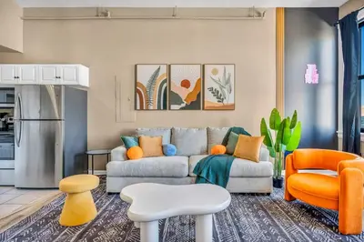 a living room with a couch and orange chairs at Funky 2B Apt in Downtown Cleveland FREE Parking in Cleveland