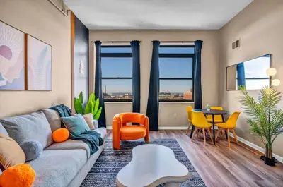 a living room with a couch and a table and chairs at Colorful 2Bed Apt Heart of Downtown Lake Views in Cleveland