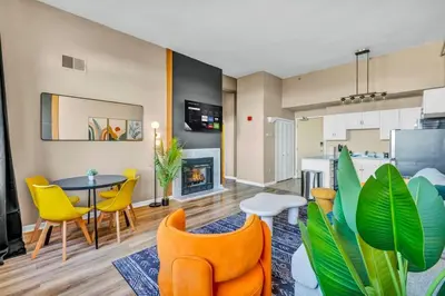 a living room with a table and chairs and a fireplace at Colorful 2Bed Apt Heart of Downtown Lake Views in Cleveland