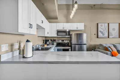 a kitchen with white cabinets and a white counter top at Colorful 2Bed Apt Heart of Downtown Lake Views in Cleveland