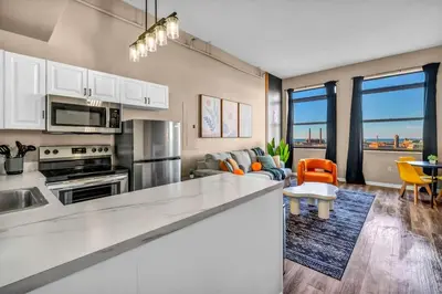 a kitchen with a counter top and a living room at Colorful 2Bed Apt Heart of Downtown Lake Views in Cleveland