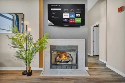 a living room with a fireplace with a tv on the wall at Colorful 2Bed Apt Heart of Downtown Lake Views in Cleveland