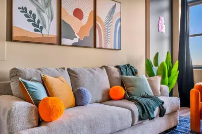 a living room with a gray couch with orange pillows at Colorful 2Bed Apt Heart of Downtown Lake Views in Cleveland