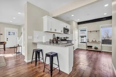 a kitchen with two bar stools and a counter top at BIG 4BR House 7 Mins to Downtown with Foosball and Games in Cleveland