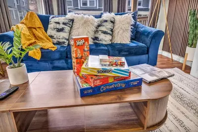 a coffee table with snacks on top of a blue couch at BIG 4BR House 7 Mins to Downtown with Foosball and Games in Cleveland
