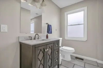 a bathroom with a sink and a toilet and a window at BIG 4BR House 7 Mins to Downtown with Foosball and Games in Cleveland
