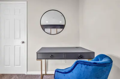 a blue chair and a table and a mirror at BIG 4BR House 7 Mins to Downtown with Foosball and Games in Cleveland