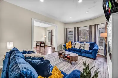 a living room with a blue couch and a table at BIG 4BR House 7 Mins to Downtown with Foosball and Games in Cleveland