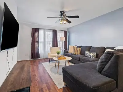 a living room with a couch and a tv at Fun 3 BR Home in Ohio City Game Room Sleeps 11 in Cleveland