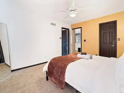 a bedroom with a large white bed and a ceiling fan at Fun 3 BR Home in Ohio City Game Room Sleeps 11 in Cleveland