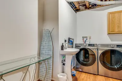 a laundry room with a washing machine and a sink at Shady Point Retreat with Hot Tub and Pickleball! in Killbuck