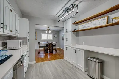 a kitchen with white cabinets and a dining room with a table at Peaceful Retreat with Private Hot Tub in New Albany in New Albany