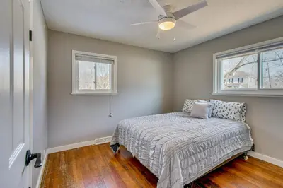 a bedroom with a bed and two windows at Peaceful Retreat with Private Hot Tub in New Albany in New Albany