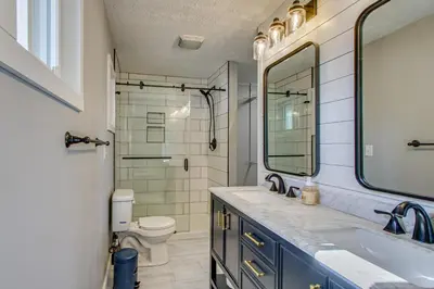 a bathroom with a sink and a toilet and a mirror at Peaceful Retreat with Private Hot Tub in New Albany in New Albany