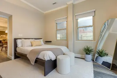a bedroom with a bed and two windows at Walk to OTR! Hot Tub and Movie Room at Cincy Condo in Cincinnati