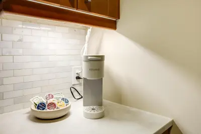 a coffee maker on a counter next to a bowl of donuts at Walkable Condo Near Over-the-Rhine and Hard Rock! in Cincinnati
