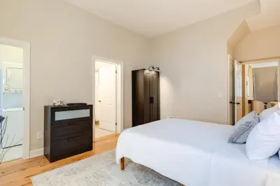 a bedroom with a large bed and a black cabinet at Walkable Condo Near Over-the-Rhine and Hard Rock! in Cincinnati