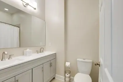 a bathroom with a toilet and a sink and a mirror at Walkable Condo Near Over-the-Rhine and Hard Rock! in Cincinnati