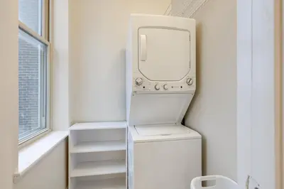 a refrigerator with a washer and dryer in a room at Walkable Condo Near Over-the-Rhine and Hard Rock! in Cincinnati