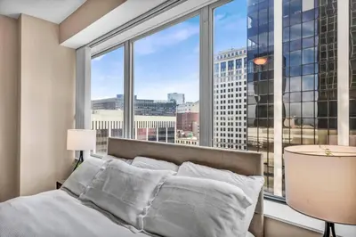 a bedroom with a bed and a large window at Downtown Flat w/ LAKE VIEW: Walk 2 Stadiums/Arenas in Cleveland