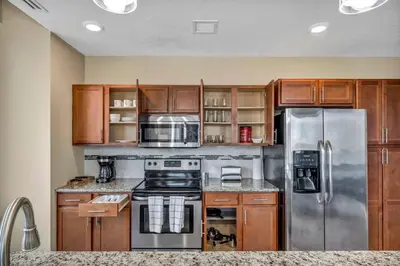 a kitchen with wooden cabinets and stainless steel appliances at Downtown Flat w/ LAKE VIEW: Walk 2 Stadiums/Arenas in Cleveland