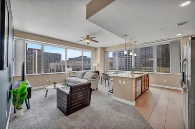 a kitchen and living room with a couch and a table at Downtown Flat w/ LAKE VIEW: Walk 2 Stadiums/Arenas in Cleveland