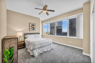 a bedroom with a bed and a large window at Downtown Flat w/ LAKE VIEW: Walk 2 Stadiums/Arenas in Cleveland