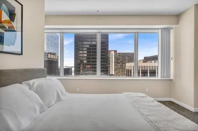 a bedroom with a large window with a view of a city at Downtown Flat w/ LAKE VIEW: Walk 2 Stadiums/Arenas in Cleveland