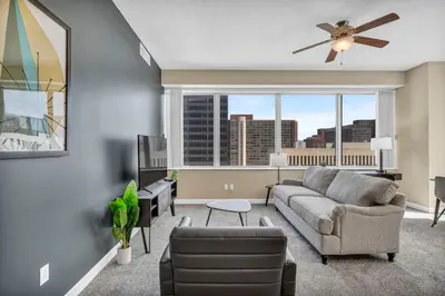 a living room with a couch and a large window at LAKE VIEWS | Paid Parking | Downtown | Gym in Cleveland