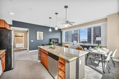 an open kitchen and living room with a dining room at LAKE VIEWS | Paid Parking | Downtown | Gym in Cleveland