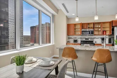 a kitchen with a table and chairs and a kitchen with windows at LAKE VIEWS | Paid Parking | Downtown | Gym in Cleveland
