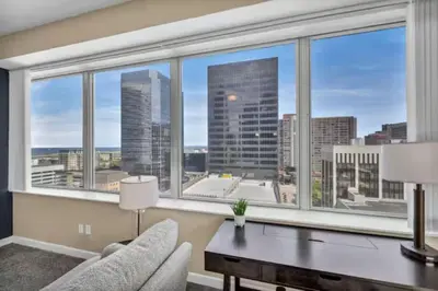 a living room with a desk and a large window at LAKE VIEWS | Paid Parking | Downtown | Gym in Cleveland