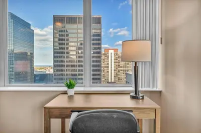 a desk with a lamp and a chair in front of a window at LAKE VIEW Sky-Suite in the Heart of Downtown! in Cleveland