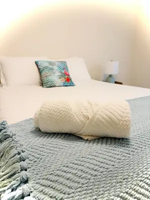 a bedroom with a bed with a blanket on it at Premier 3BR Retreat - CVNP, Blossom & Boston Hills in Cuyahoga Falls