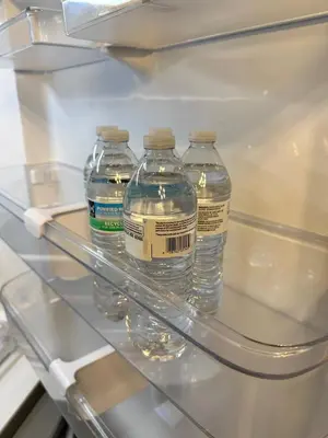 three bottles of water are sitting in a refrigerator at Premier 3BR Retreat - CVNP, Blossom & Boston Hills in Cuyahoga Falls