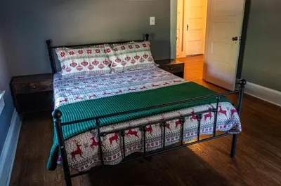 a bed with a quilt on it in a bedroom at 4BR- Downtown Christmas Home in Millersburg