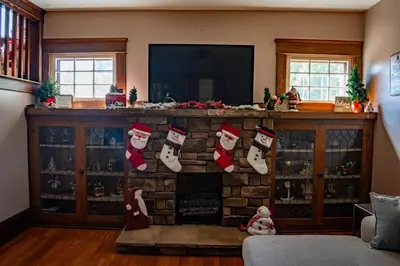 a living room with christmas stockings on a fireplace at 4BR- Downtown Christmas Home in Millersburg