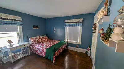 a bedroom with a bed in a room with blue walls at 4BR- Downtown Christmas Home in Millersburg