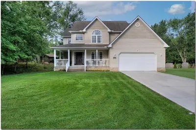 a house with a large yard with a driveway at Modern home near Cleveland in Seven Hills