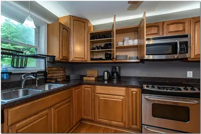a kitchen with wooden cabinets and a sink and a microwave at Modern home near Cleveland in Seven Hills