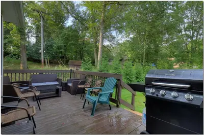 a deck with a stove and chairs and a grill at Modern home near Cleveland in Seven Hills